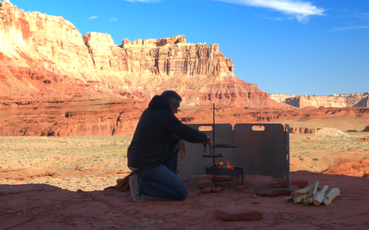 Man cooking overtop of a campfire in a grand cayon