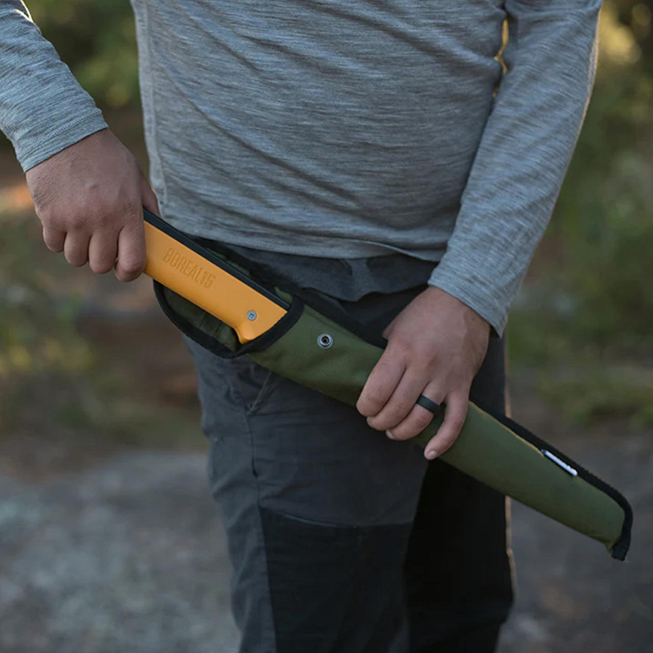 A man holding the Agawa 21 Olive Cordura sheath in his left hand while pulling the Boreal saw from the sheath with his right hand, highlighting the sheath's durability and functionality.






